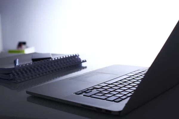 सफेद पृष्ठभूमि पर टेबल पर फ़ोल्डरों के ढेर के साथ लैपटॉप — स्टॉक फ़ोटो, इमेज
