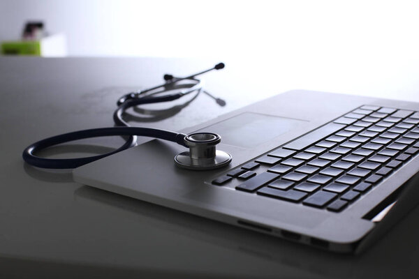 Workplace of doctor with laptop and stethoscope and notebook