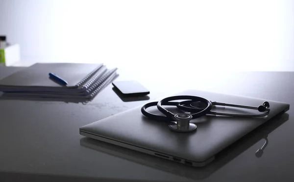 Local de trabalho do médico com laptop e estetoscópio e caderno — Fotografia de Stock