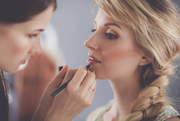 Kunstenaar doet professionele make-up van vrouw — Stockfoto