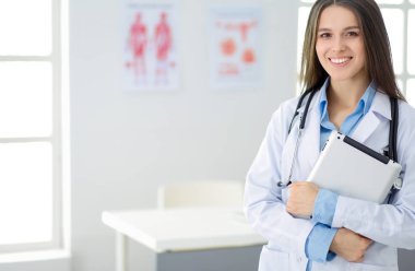 Hastane lobisinde tablet bilgisayar kullanan kadın doktor.