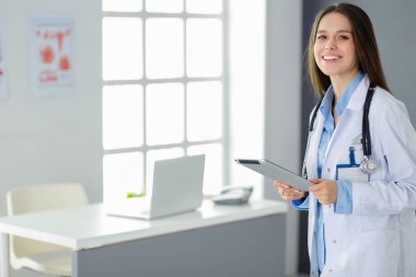 Hastane lobisinde tablet bilgisayar kullanan kadın doktor.