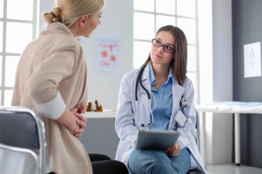 Doktor ve hasta masada otururken bir şey tartışıyorlar. İlaç ve sağlık hizmetleri kavramı