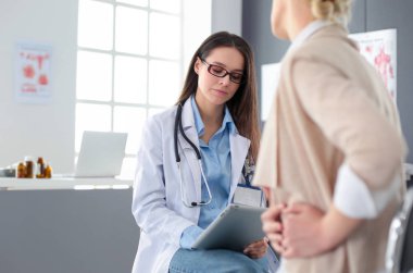 Doktor ve hasta masada otururken bir şey tartışıyorlar. İlaç ve sağlık hizmetleri kavramı