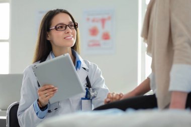 Doktor ve hasta masada otururken bir şey tartışıyorlar. İlaç ve sağlık hizmetleri kavramı