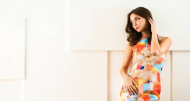 Beyaz arka planda poz veren güzel bir kadın.