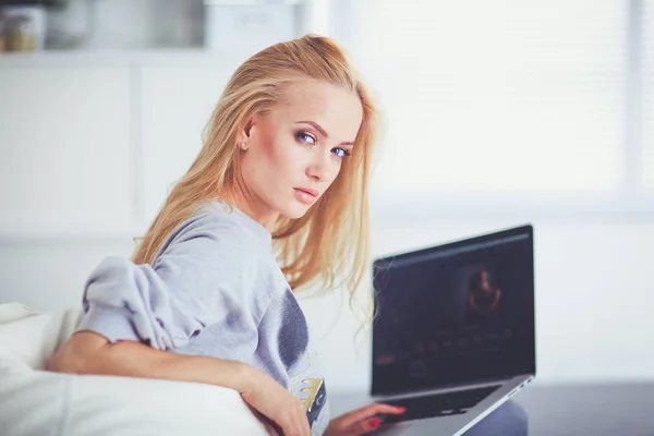 Jovem mulher bonita usando um computador portátil em casa — Fotografia de Stock