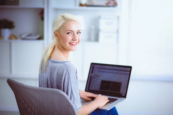 Genç ve güzel bir kadın evde dizüstü bilgisayar kullanıyor. — Stok fotoğraf
