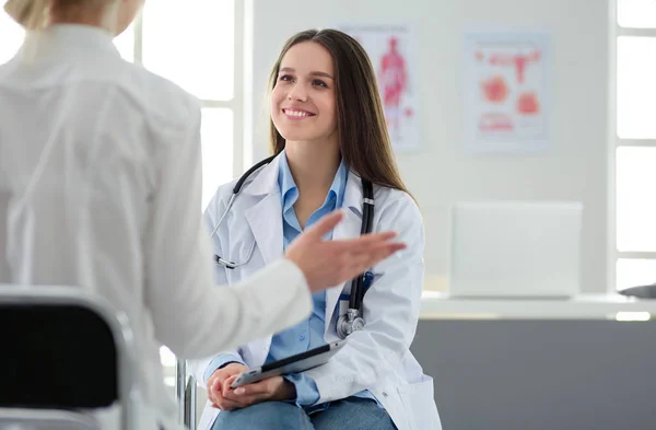 Dokter en patiënt bespreken iets terwijl ze aan tafel zitten. Begrip "geneeskunde en gezondheidszorg" — Stockfoto