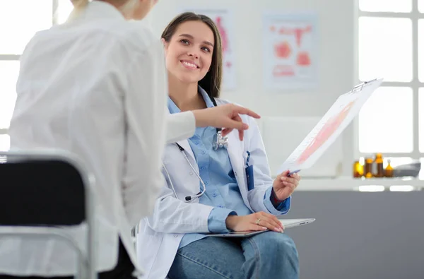 Dokter en patiënt bespreken iets terwijl ze aan tafel zitten. Begrip "geneeskunde en gezondheidszorg" — Stockfoto