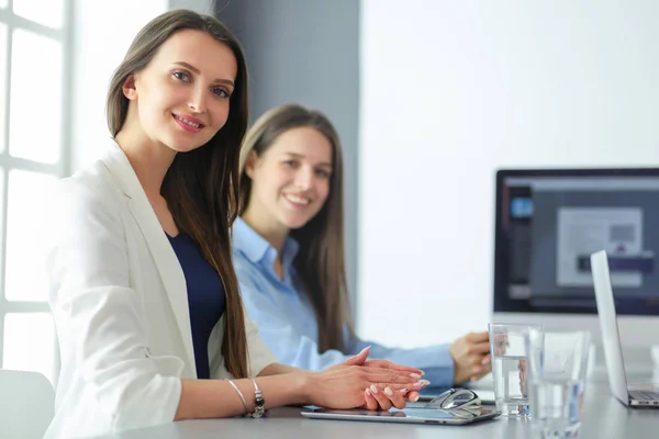 Zwei Bürokolleginnen sitzen auf dem Schreibtisch — Stockfoto