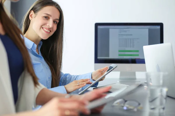 Zwei Bürokolleginnen sitzen auf dem Schreibtisch — Stockfoto