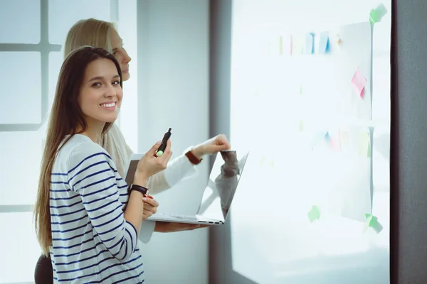 Nahaufnahme einer Geschäftsfrau, die im Büro im Flipchart schreibt — Stockfoto