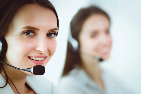 Mujer de negocios sonriente u operador de línea de ayuda con auriculares y computadora en la oficina — Foto de Stock