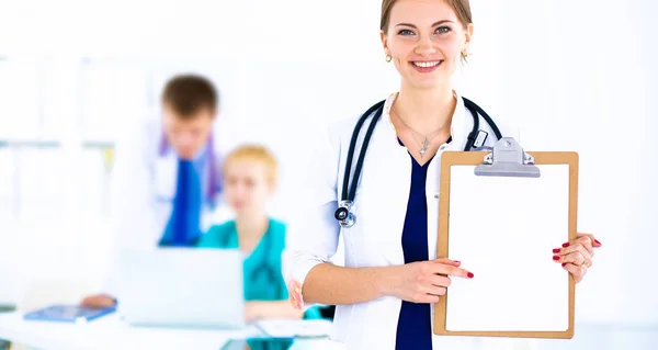 Attractive female doctor  with folder in front of medical group — Stock Photo, Image