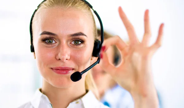 Smiling customer service girl showing ok, isolated on white background.