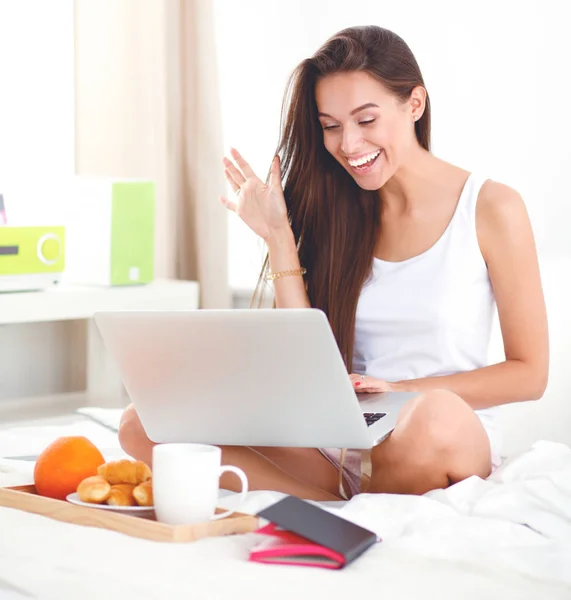 Jonge mooie vrouw zitten in bed — Stockfoto