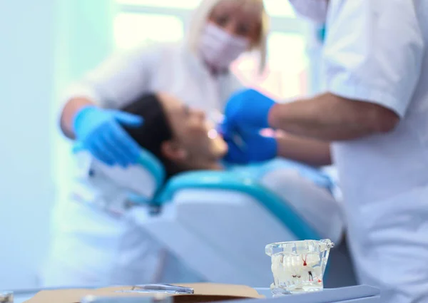 Retrato de um dentista que trata dentes de paciente jovem — Fotografia de Stock