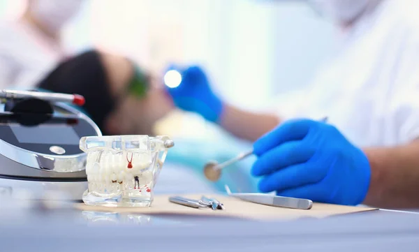 Senior male dentist adjust searchlight before starting work — Stock Photo, Image