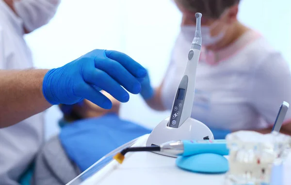 Detalhe de mão segurando ferramentas dentárias na clínica odontológica. Conceito de dentista — Fotografia de Stock