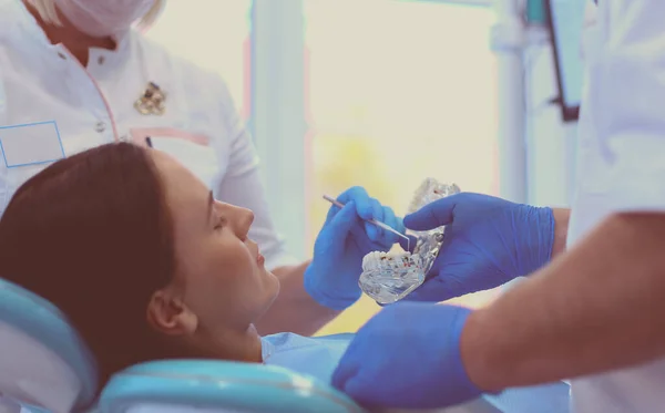 Diş kliniğinde duran gülümseyen bir dişçinin portresi. — Stok fotoğraf
