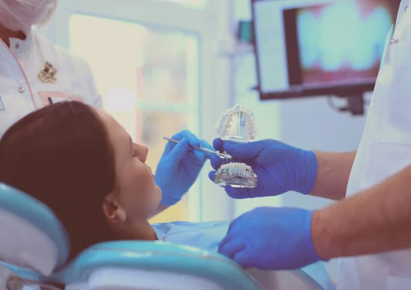 Diş muayenehanesinde kıdemli erkek dişçi kadın hastayla konuşuyor ve tedaviye hazırlanıyor. — Stok fotoğraf