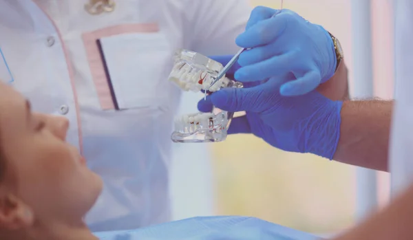 Dentista masculino senior en consultorio dental hablando con paciente femenino y preparándose para el tratamiento — Foto de Stock