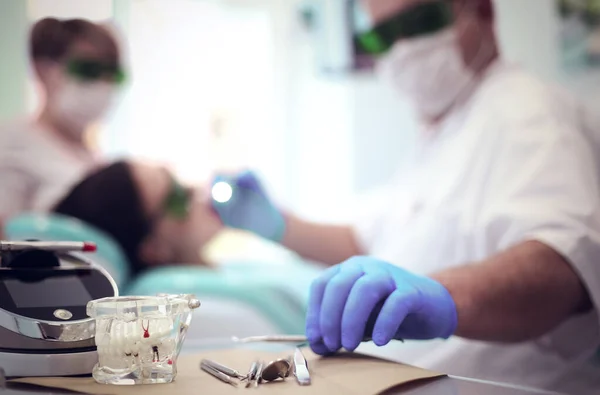 Dentista sênior do sexo masculino ajustar holofote antes de iniciar o trabalho — Fotografia de Stock