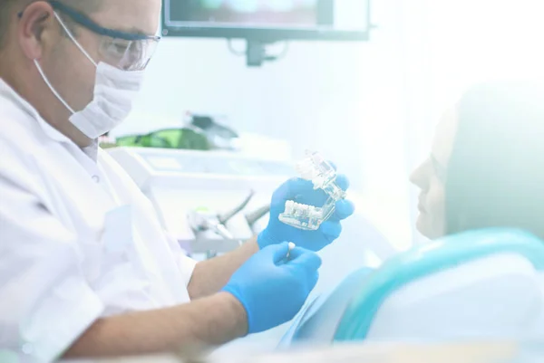 Médico dentista sênior em consultório odontológico conversando com paciente do sexo feminino e se preparando para o tratamento — Fotografia de Stock