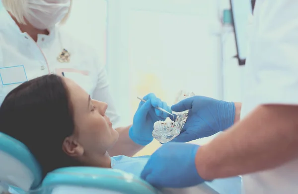 Diş kliniğinde duran gülümseyen bir dişçinin portresi. — Stok fotoğraf