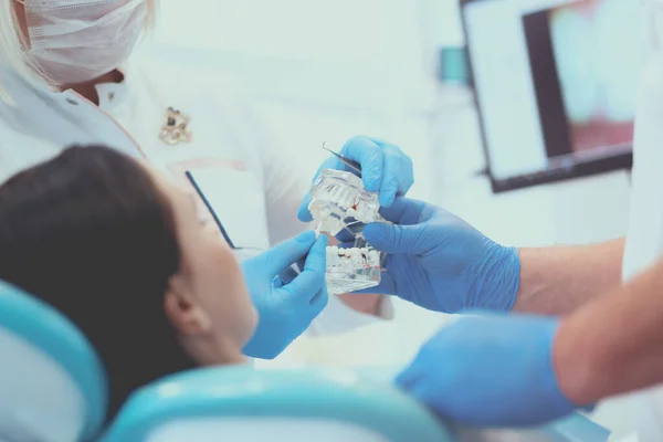 歯科の上級男性歯科医は女性患者と話し、治療の準備をしています — ストック写真