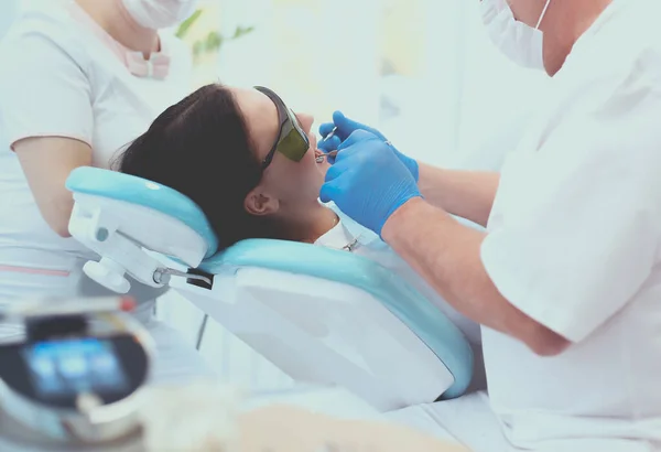 Чоловік стоматолог працює на зубах пацієнтів — стокове фото