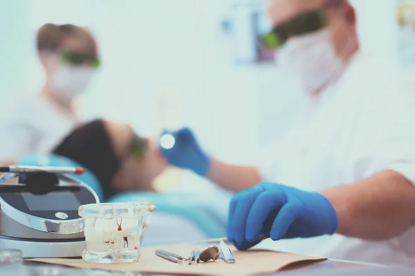 シニア男性歯科医は仕事を始める前にサーチライトを調整します — ストック写真