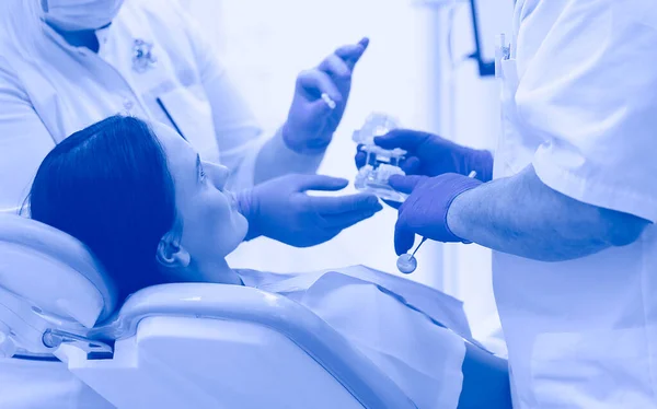 Portrait of a dentist who treats teeth of young woman patient — Stock Photo, Image