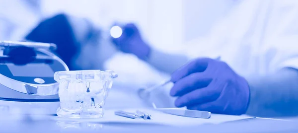 Senior male dentist adjust searchlight before starting work — Stock Photo, Image