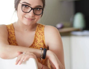 Mutfakta masada oturan genç bir kadın.