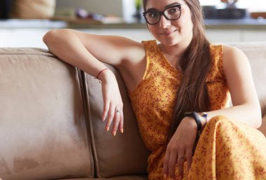 Kanepede oturan gülümseyen kadın portresi. Günlük tarz kapalı çekim.