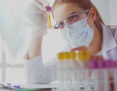 Hastanedeki kan örneğini analiz eden güzel bir kadın laboratuvar asistanı portresi.