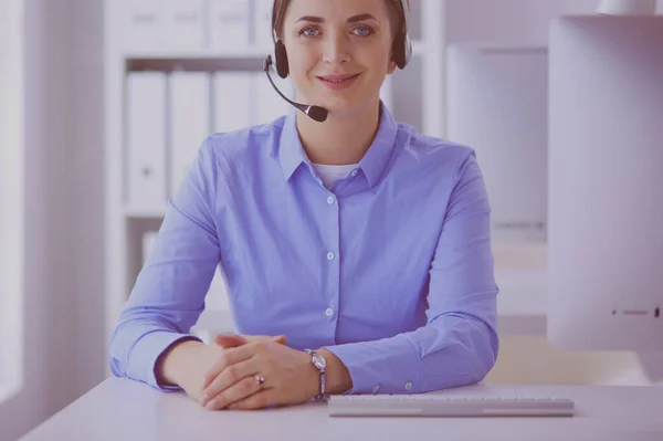 Ernsthafte hübsche junge Frau arbeitet als Telefonistin mit Headset im Büro — Stockfoto