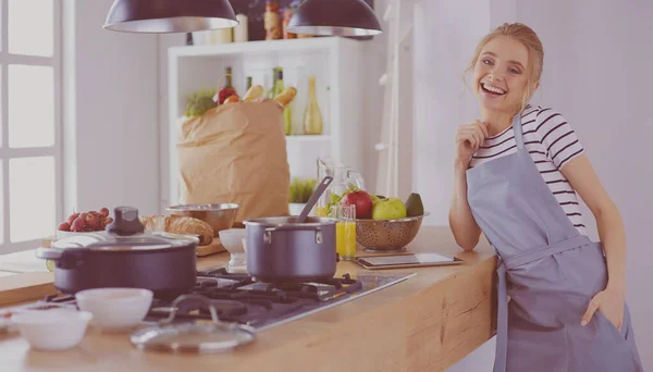 Schöne junge Frau kocht zu Hause in der Küche — Stockfoto