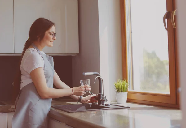 Frauenhände füllen das Glas Wasser — Stockfoto