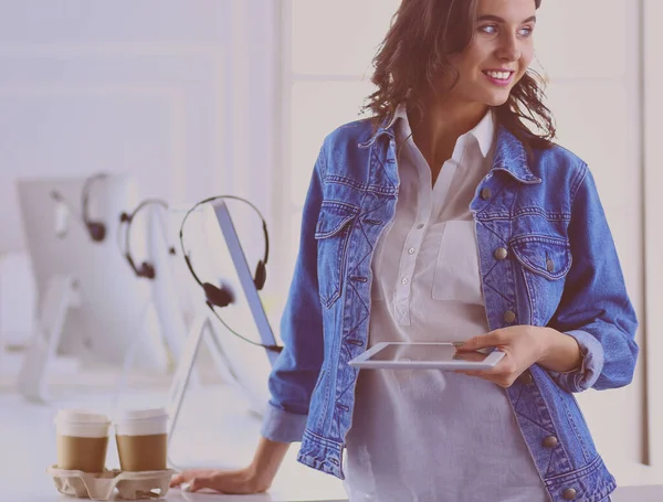 Mujer sonriente bebiendo café y usando la tableta en el café — Foto de Stock