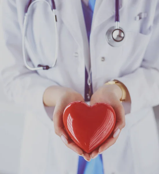 Female doctor with stethoscope holding heart, on light background — Stock Photo, Image