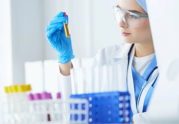 Asistente de laboratorio mujer analizando una muestra de sangre — Foto de Stock