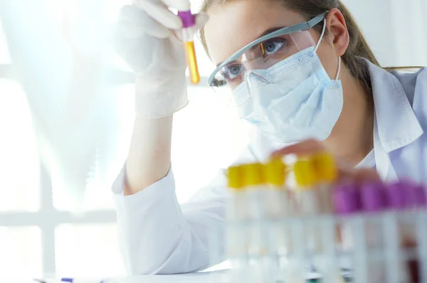 Retrato de una asistente de laboratorio bastante femenina analizando una muestra de sangre en el hospital — Foto de Stock