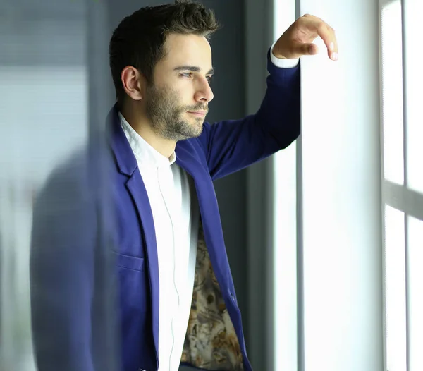 Business man in suit talking on phone and looking away near the window. — Stock Photo, Image