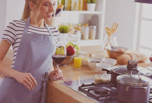 Mooie vrouw die thuis wat wijn drinkt in de keuken — Stockfoto