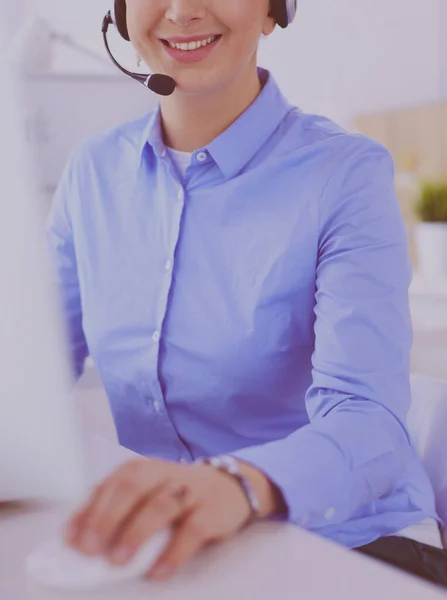 Ernstige mooie jonge vrouw die werkt als support telefoon operator met headset in het kantoor — Stockfoto