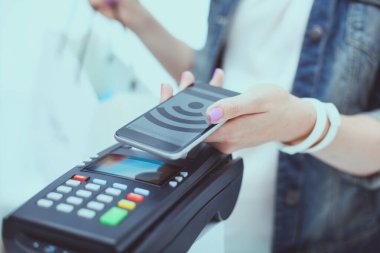 Müşteri ile smartphone Nfc teknolojisi kullanılarak dükkanda ödüyor. NFC teknolojisi. Müşteri ödeme