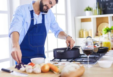 Adam ev mutfağında lezzetli ve sağlıklı yemekler hazırlıyor.